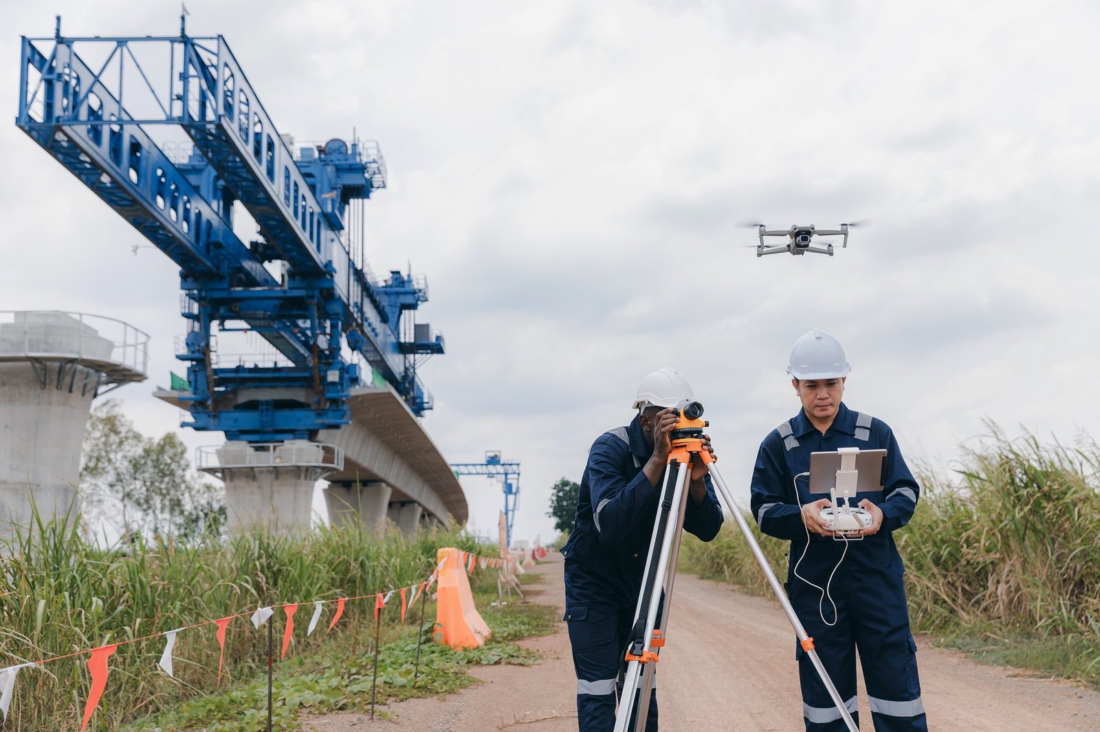 Engineer surveyor team Use drone for operator inspecting and survey construction site.